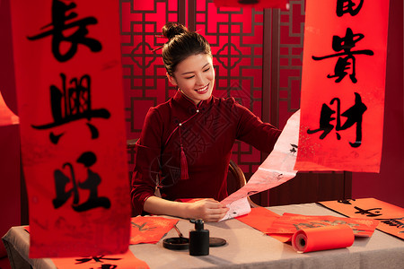 中国屏风旗袍美女拿着刚写好的春联背景