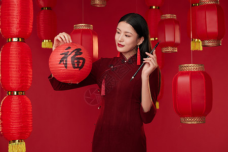 中国传统旗袍服饰拿着红灯笼和毛笔的旗袍美女背景