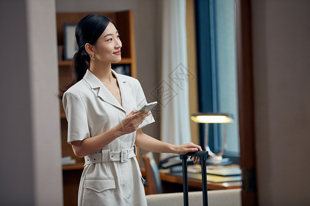 拖着行李箱入住酒店的女白领高清图片