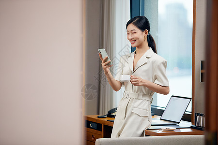 酒店电脑在商旅酒店看手机的女白领背景