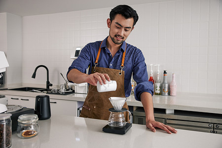 咖啡师向过滤壶里倒咖啡粉背景图片