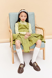 穿着成熟裙子小女孩坐椅子上高清图片