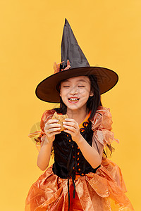 万圣帽子吃甜点的万圣节小女巫背景
