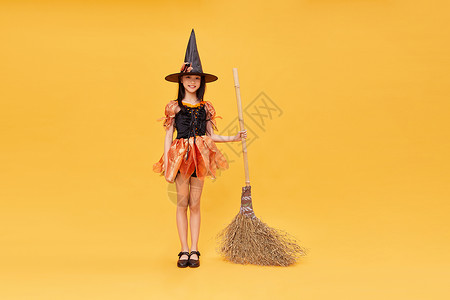 遮阳儿童帽拿着扫把的万圣节小女巫背景