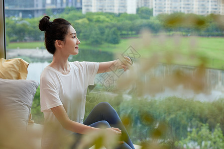 坐在窗边的独居女性形象图片