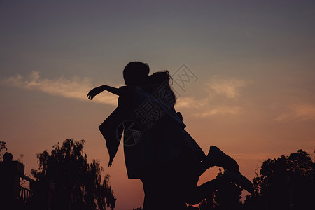 夕阳下的拥抱的情侣剪影背景图片