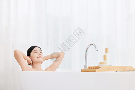 青年女性躺在浴缸享受泡泡浴图片
