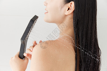 洗发水美女美女手拿花洒洗澡背景