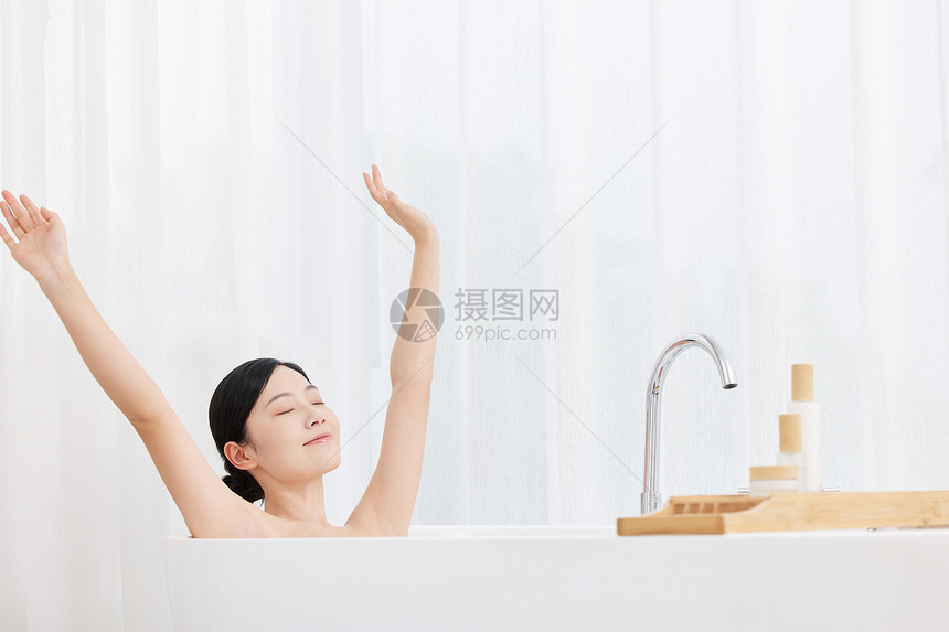 年轻女性泡澡伸展手臂图片