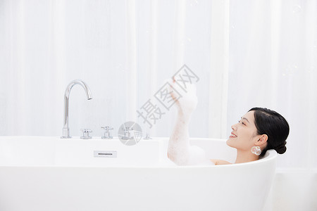 女性躺在浴缸洗泡泡浴图片