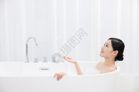年轻女性躺在浴缸洗泡泡浴高清图片