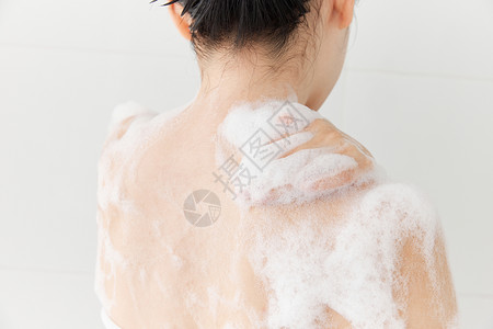 摸胳膊女性使用沐浴球洗澡背部特写背景