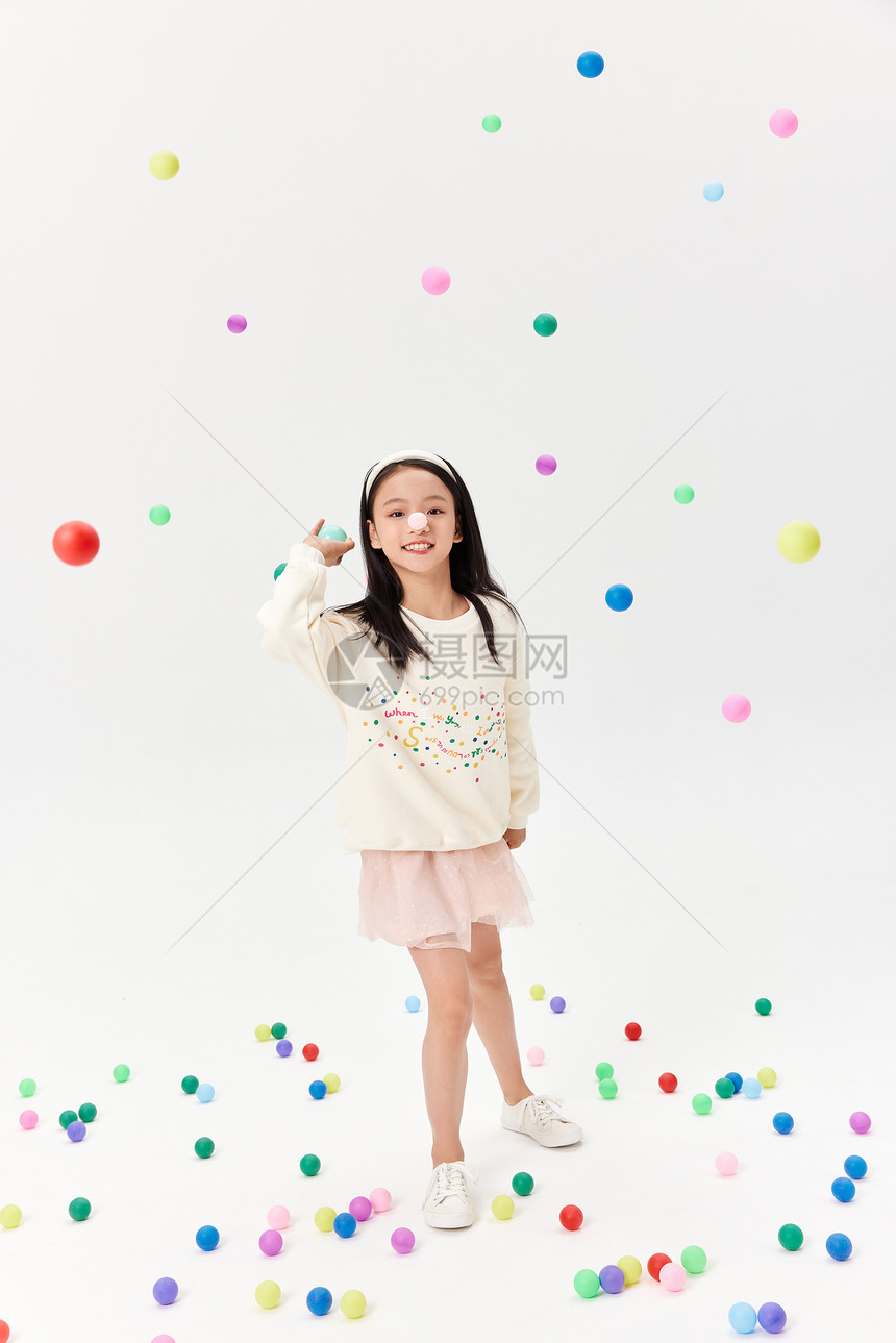 甜美可爱小女孩扔彩色乓乓球图片