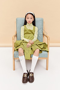 坐椅子上的绿西装高冷少女背景图片