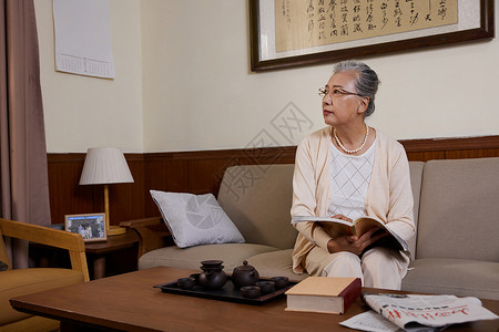 老奶奶晚年生活居家看书等候亲人背景图片