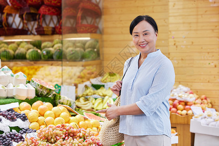 水果店购买水果的中年女性高清图片