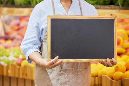 超市水果店店员手拿小黑板特写图片