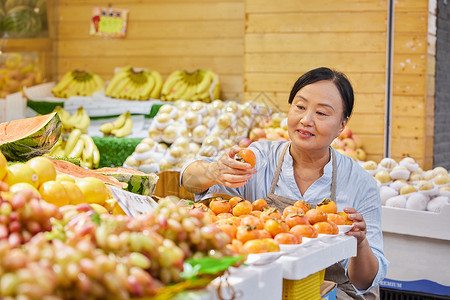 中年水果店员工检查水果品质高清图片