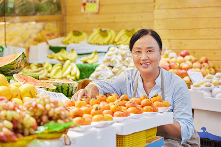 中年水果店员工检查橘子高清图片