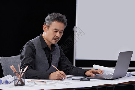 建筑设计师使用电脑与纸张高清图片