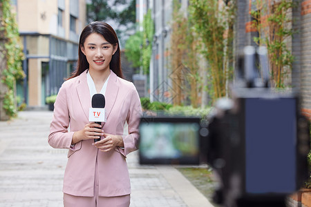 摄像机前的户外新闻女记者背景图片