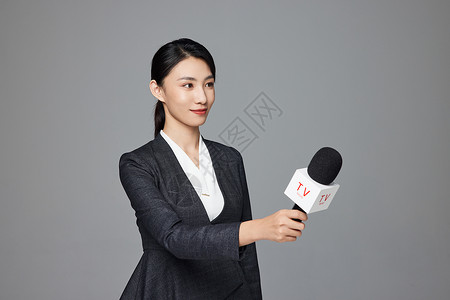 手拿话筒采访的青年女性新闻记者背景图片
