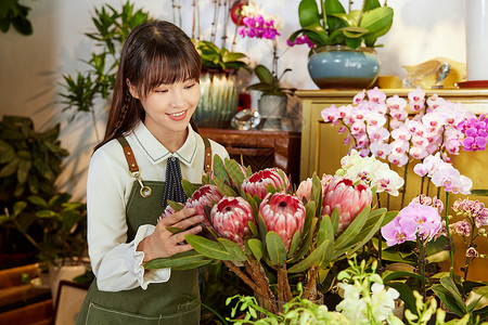 鲜花店美女销售员查看鲜花背景图片