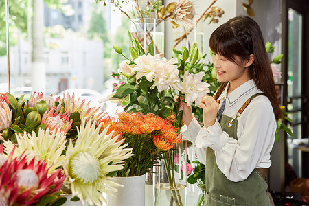 鲜花店美女销售员查看鲜花背景图片