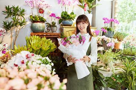 花艺店美女服务员手捧鲜花花束高清图片