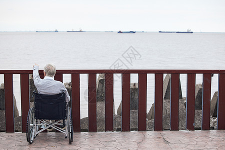 孤独看海的轮椅老人背影背景图片