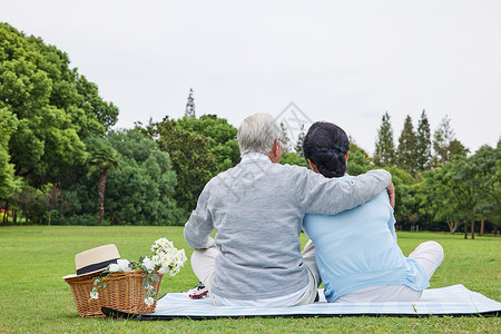 坐在草地上休息的老年夫妻背影图片