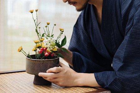 生活着装物件日系男性手拿花枝插花特写背景