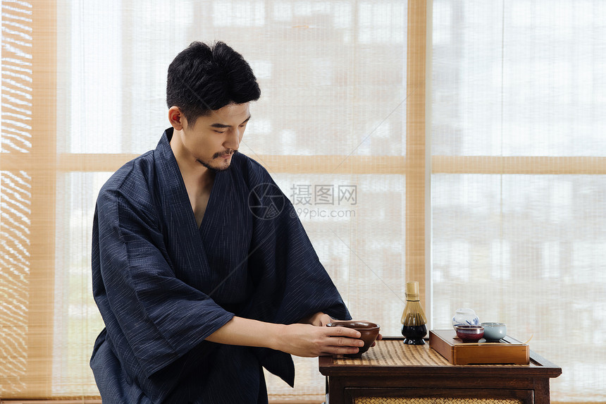 日系男性手拿茶碗喝茶图片
