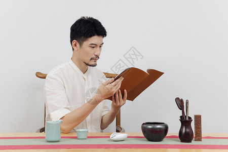 青年男性茶艺师看书背景图片