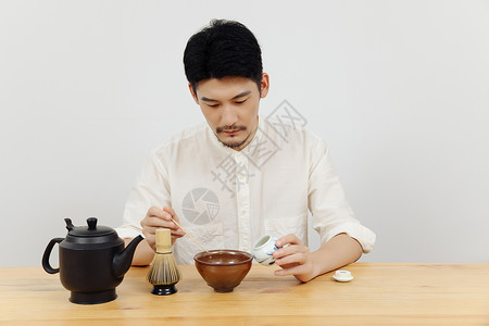 茶艺师使用茶勺取抹茶粉背景图片