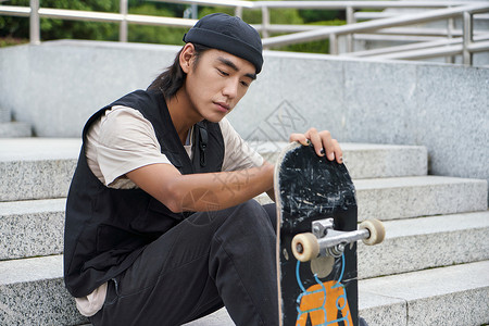 青年男性手拿滑板形象背景图片