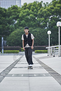 户外玩滑板的青年男性高清图片