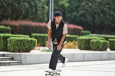 青年男性户外玩滑板高清图片