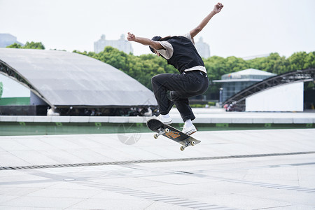 城市上跳跃滑板少年户外玩滑板背景