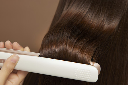 女性美发使用直板夹做造型特写高清图片