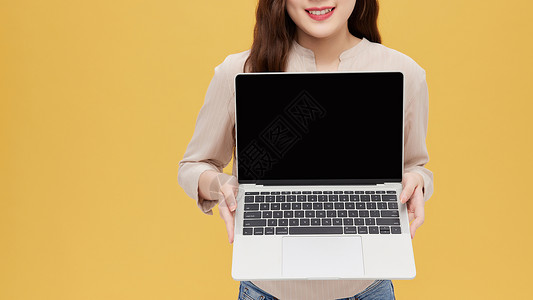 手拿电脑展示的青年女性特写图片