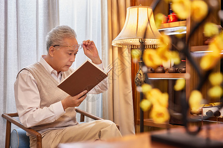 近视远视视力不好的老人在家看书背景