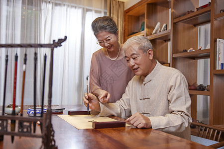 老奶奶在家陪伴老爷爷练习书法高清图片