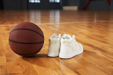 白色球鞋室内篮球场地板上的篮球和篮球鞋背景