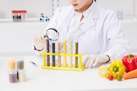女性营养师观察食品样本营养师用放大镜检测食品安全特写背景