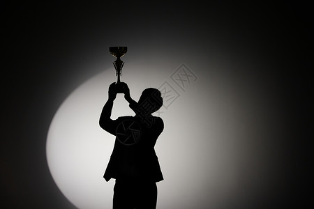 排名背景拿着奖杯的商务男性剪影背景