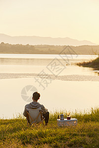 年轻男生坐在湖边背影图片