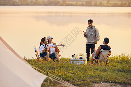 年轻人傍晚在湖边聚会聊天图片