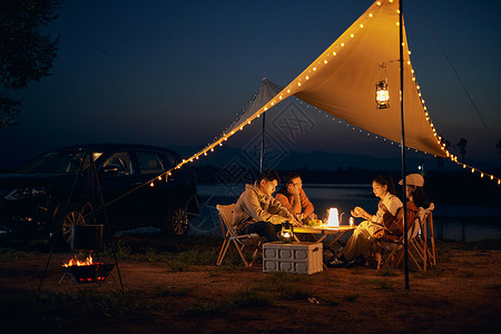 年轻朋友夜晚户外野营聚会背景图片