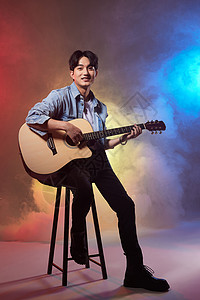 多彩创意男性歌手坐着弹吉他高清图片